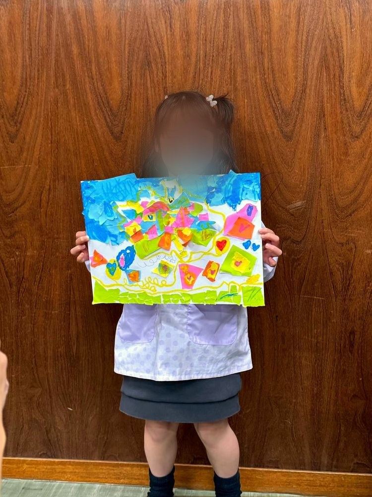 A girl holding her artwork