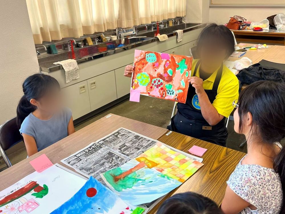 A teacher showing the children’s artwork