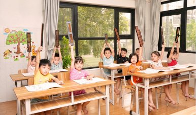 Children at our Hanoi school holding their soroban above their heads