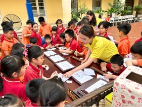 A teacher showing a student how to use the soroban