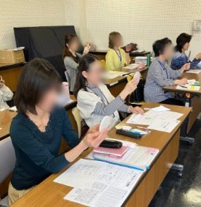 Teachers practicing their smiles at a training session