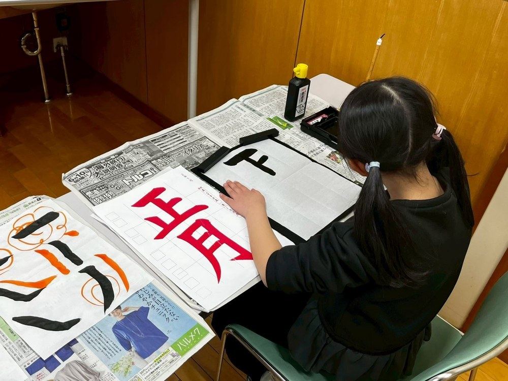 Children and their teacher with their calligraphy work