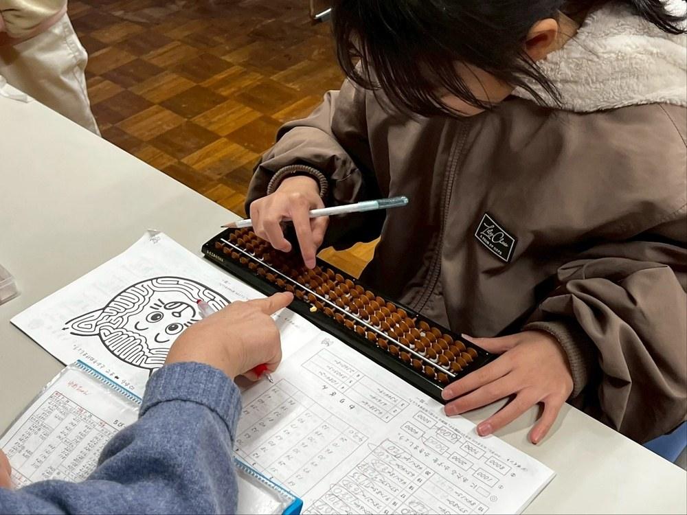 A child solving problems on a soroban
