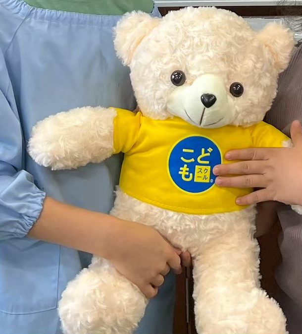 黄色のTシャツを着た、わくま君のぬいぐるみ
